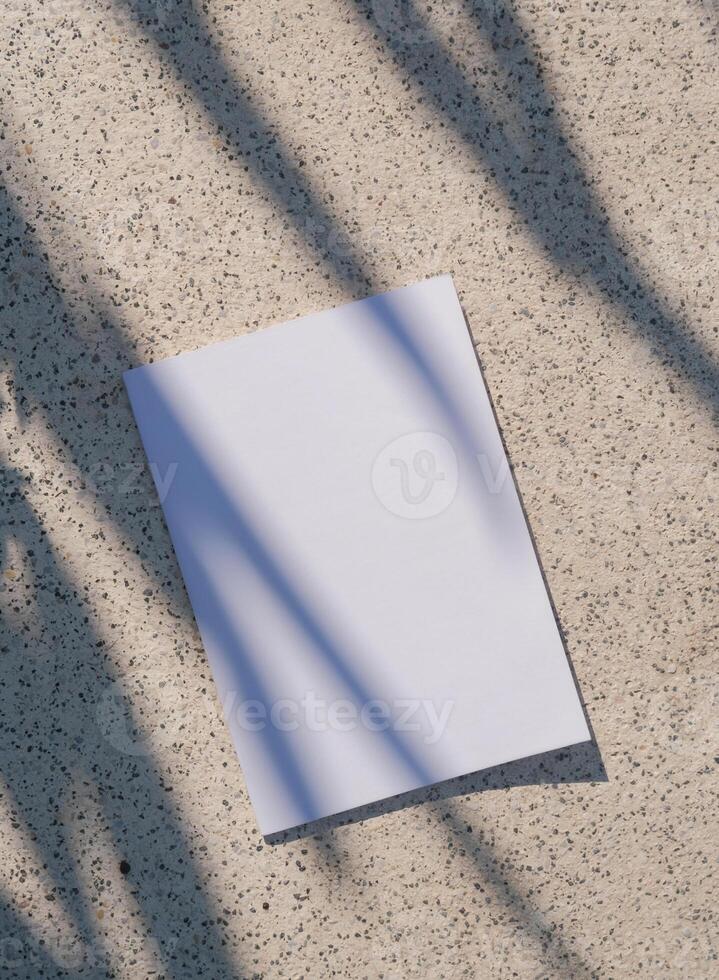 empty paper poster mockup on concrete stone floor or pavement outdoors, shadow overlay photo