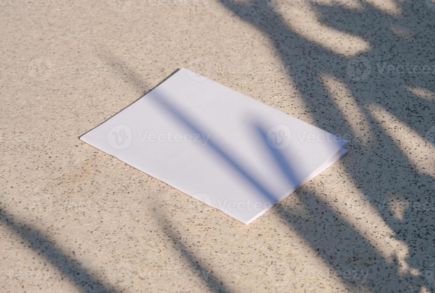 empty vertical magazine mockup on concrete stone floor or pavement outdoors, shadow overlay photo