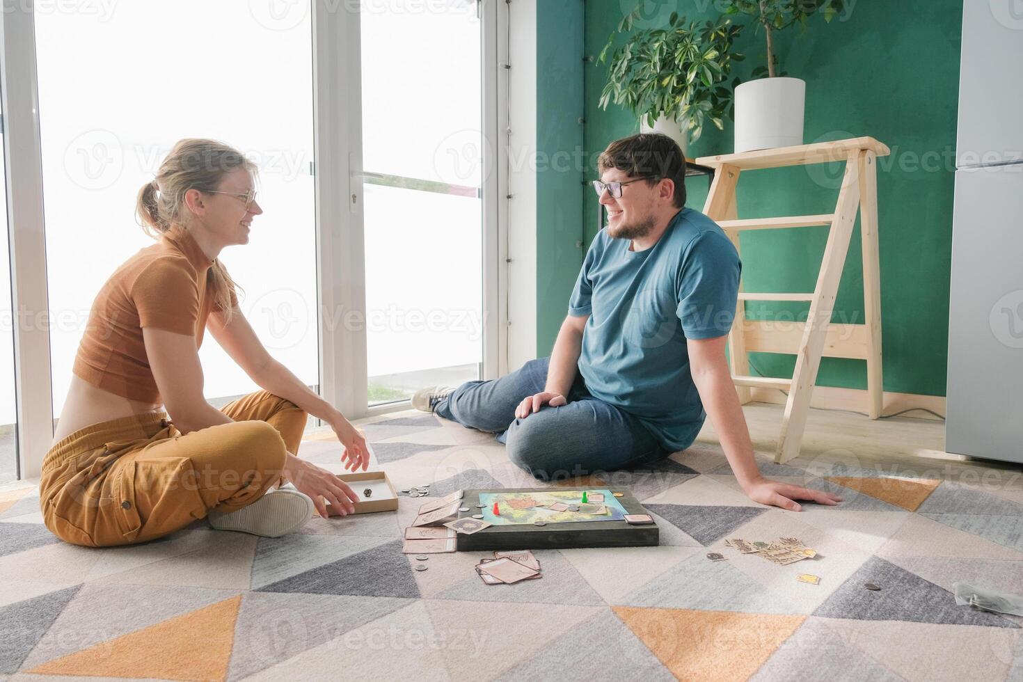 Beautiful young couple having fun playing board game at home photo