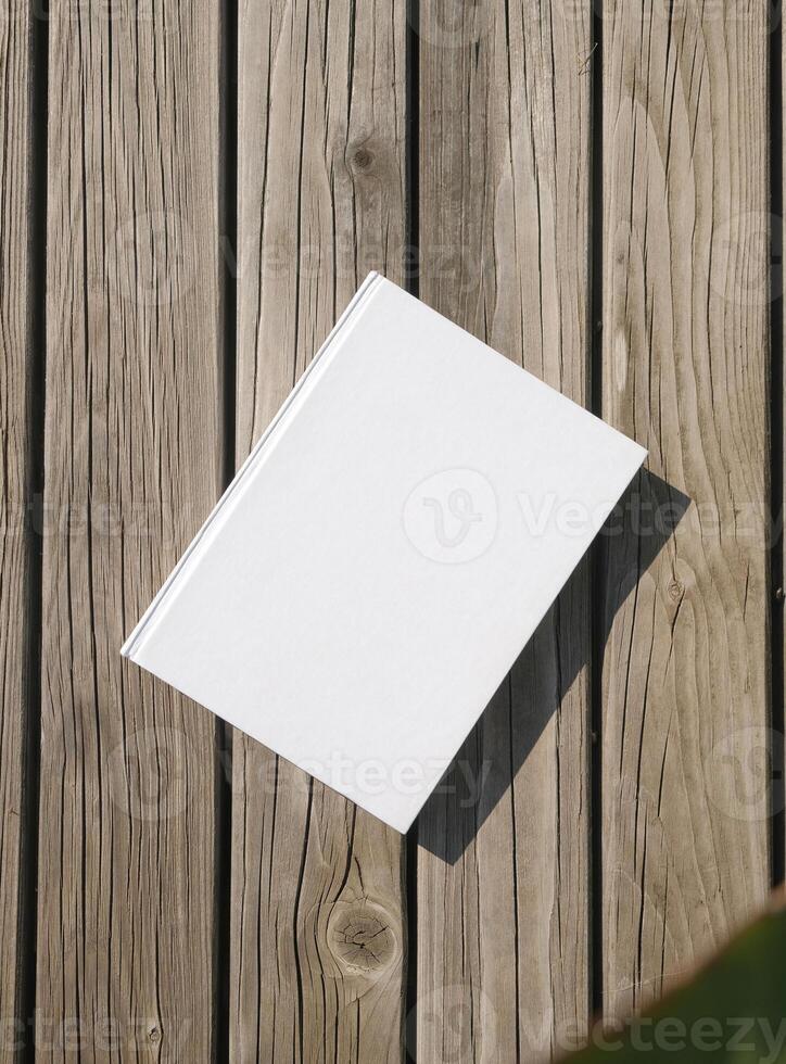 blank book mockup on rustic wooden background, top view photo
