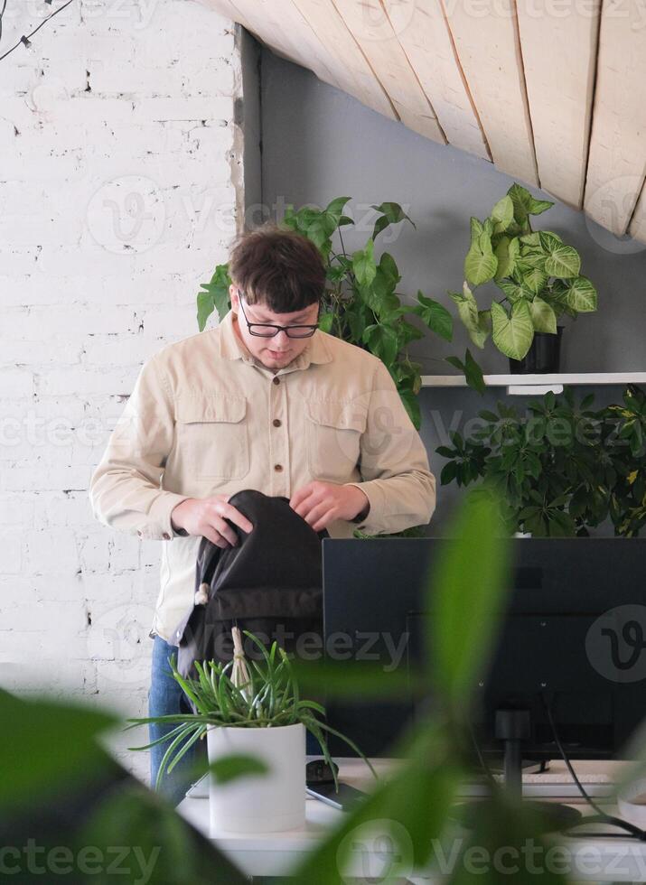 millenni man in stylish casual clothes using smartphone and computer while spending time at home photo