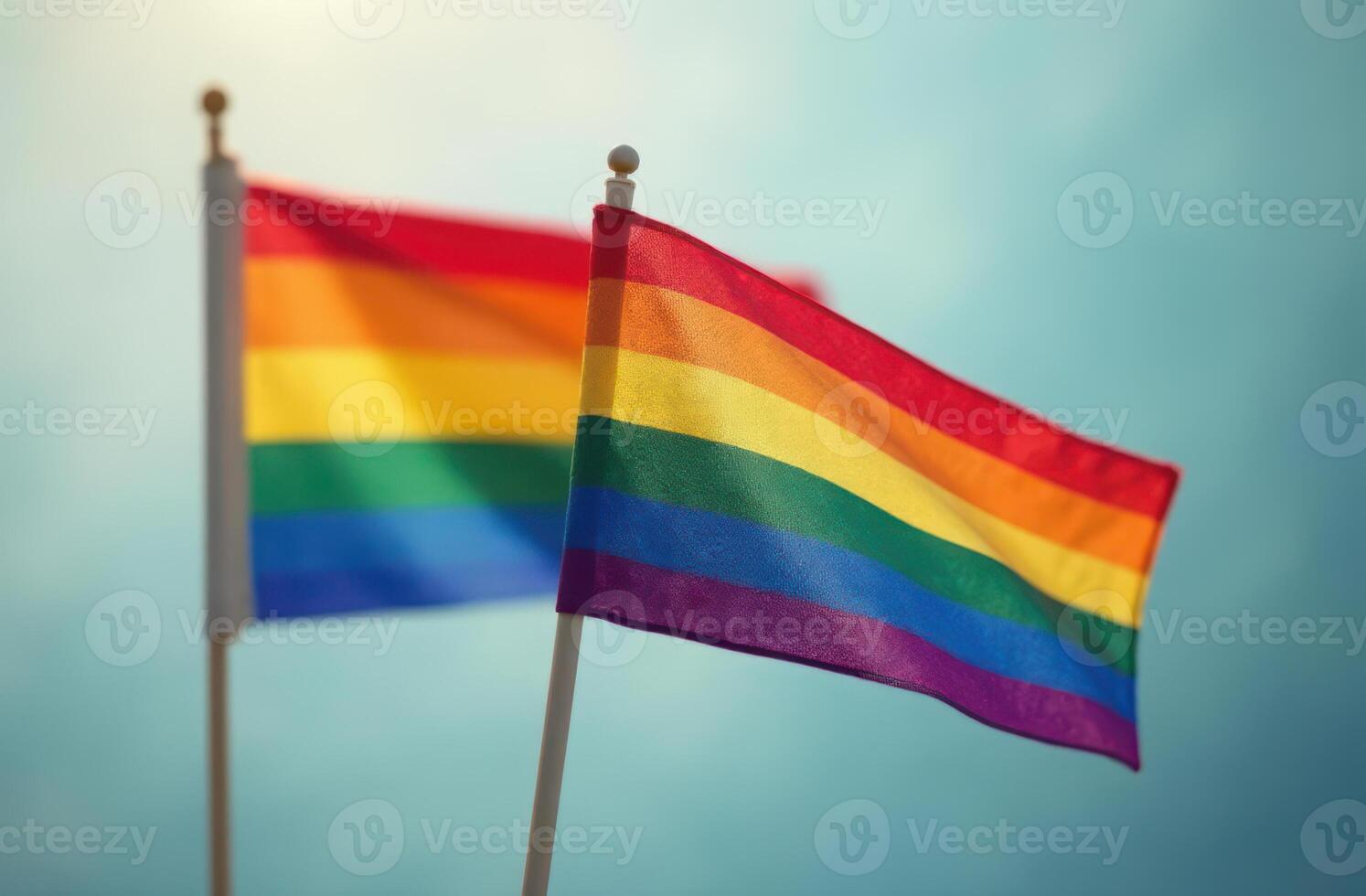 Vibrant rainbow flags waving against a clear blue sky. LGBT Pride month photo