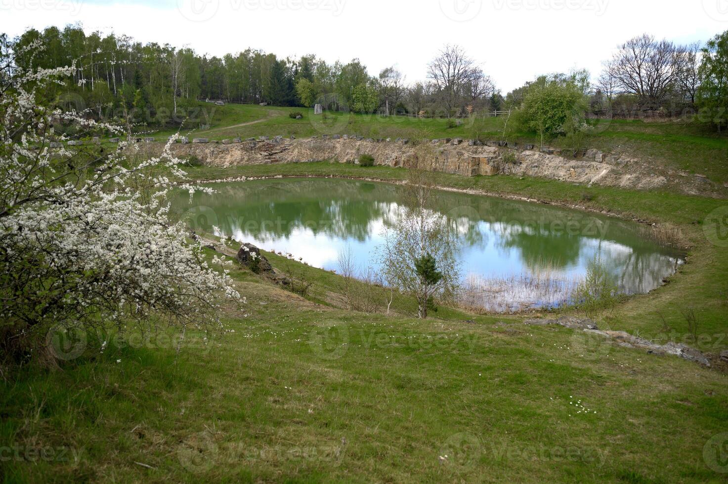 A lake with turquoise water and rocks around it in Skrylle Lund Skane Sweden. photo