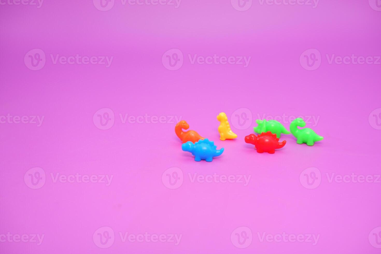 Fun Dinosaur Figures in Bold Colors on Purple Background photo