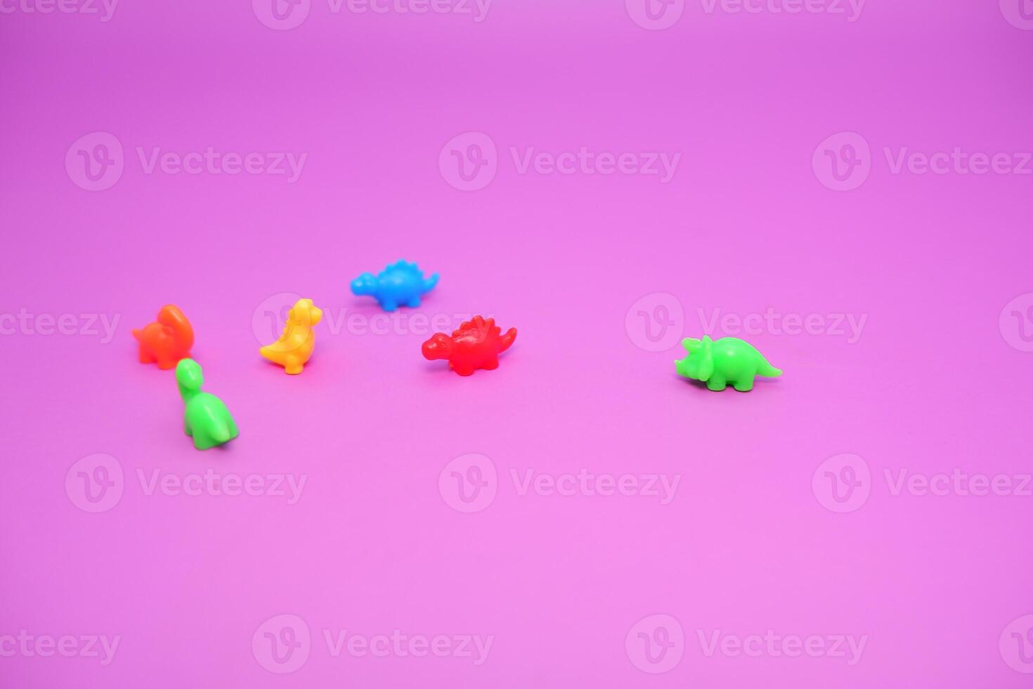 Vibrant Dinosaur Toys Lined Up on a Colorful Surface photo