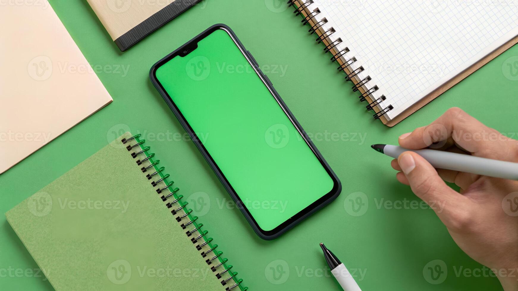 Phone with Green Screen and Notebooks on a Green Background photo