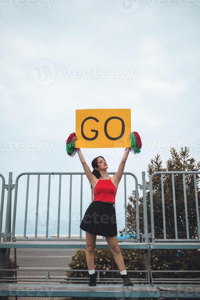Young Women Cheers Her Heart Basketball Team On The Stands photo