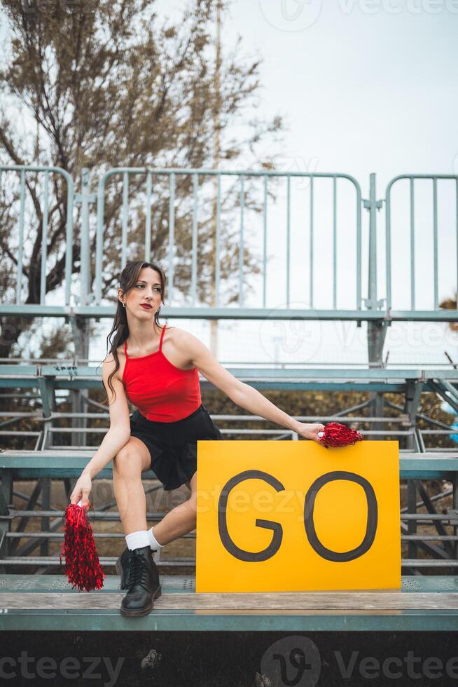 Cheerleader Young Women Cheers Her Heart Basketball Team On The Stands photo