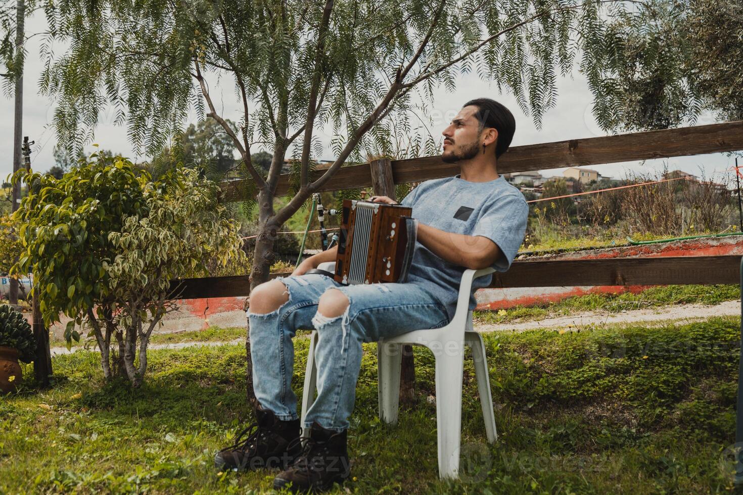 Man With Accordion Relaxing On A Chair Outdoor photo