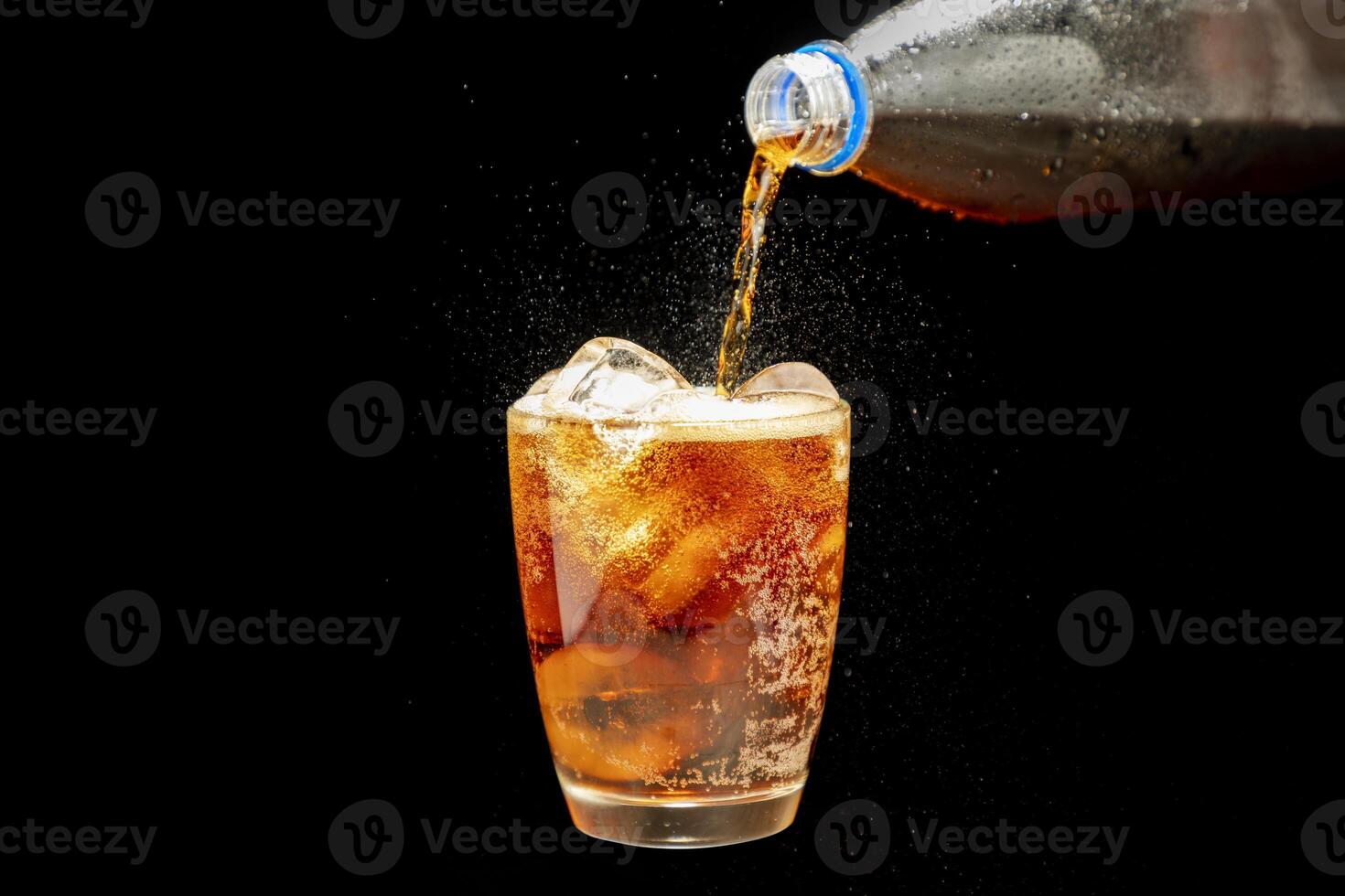 Cola drink, soda in glass with ice, refreshing splash water, isolated on black background. photo