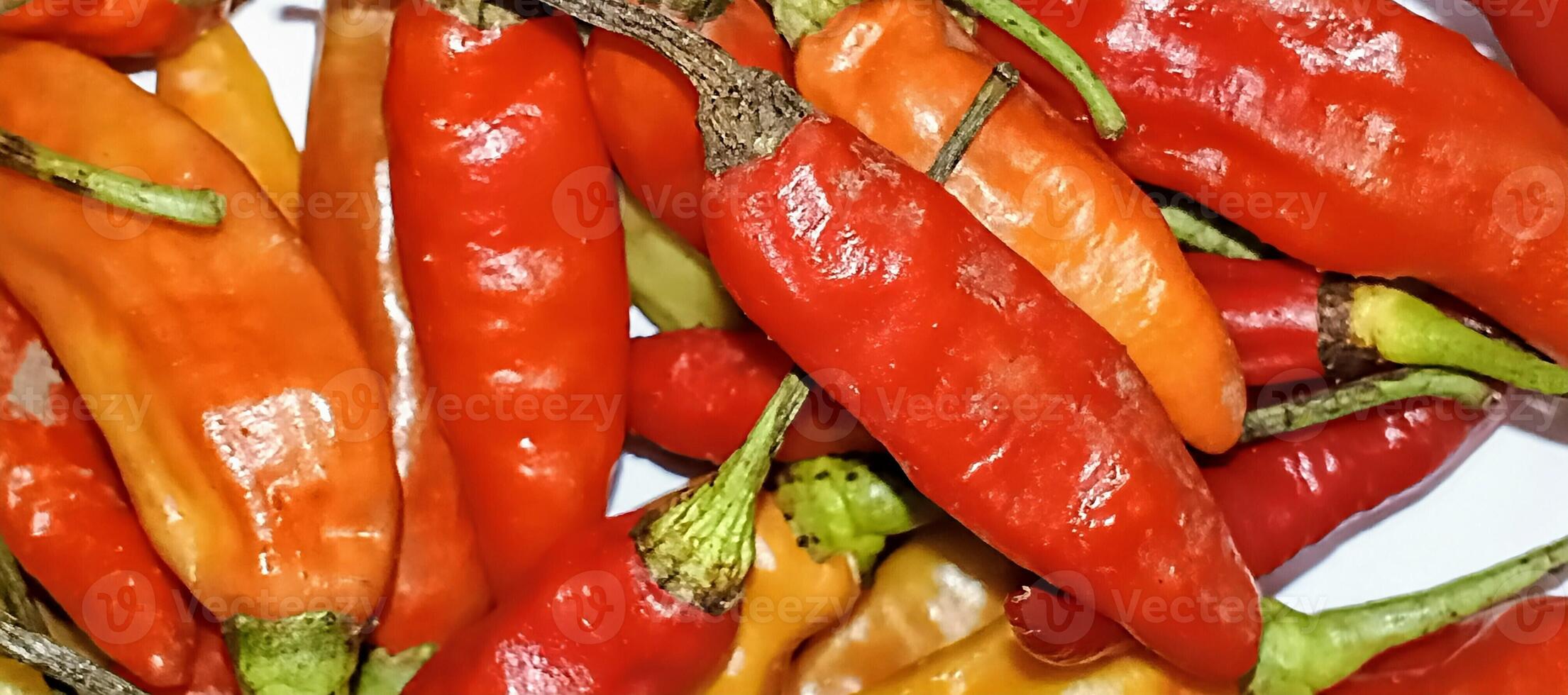 Close-up image of fresh red and orange chili peppers, showing vibrant colors and textured surfaces for food photography. photo