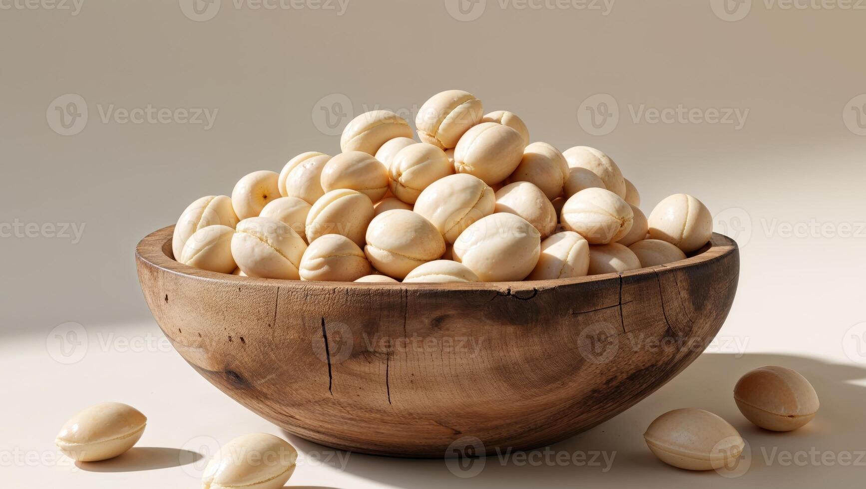 Rustic wooden bowl filled with fresh macadamia nuts photo