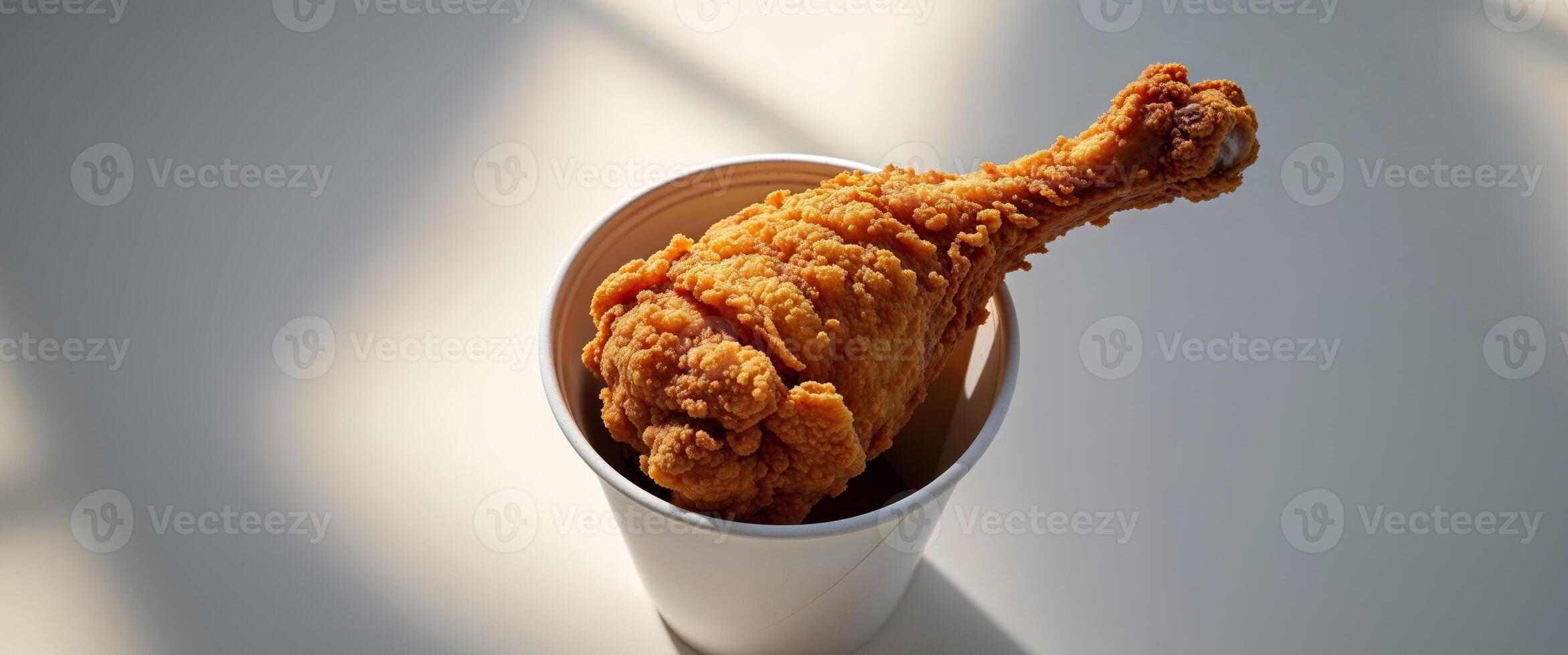 Delicious Crispy Fried Chicken Drumsticks in a White Paper Cup. photo