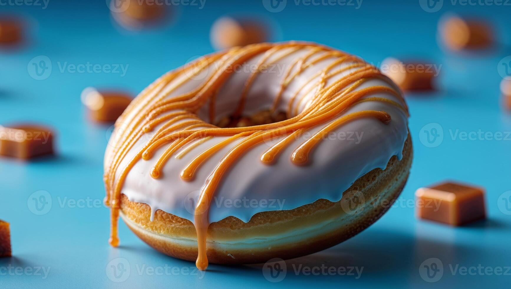 A donut with caramel drizzle and candies on a blue surface photo