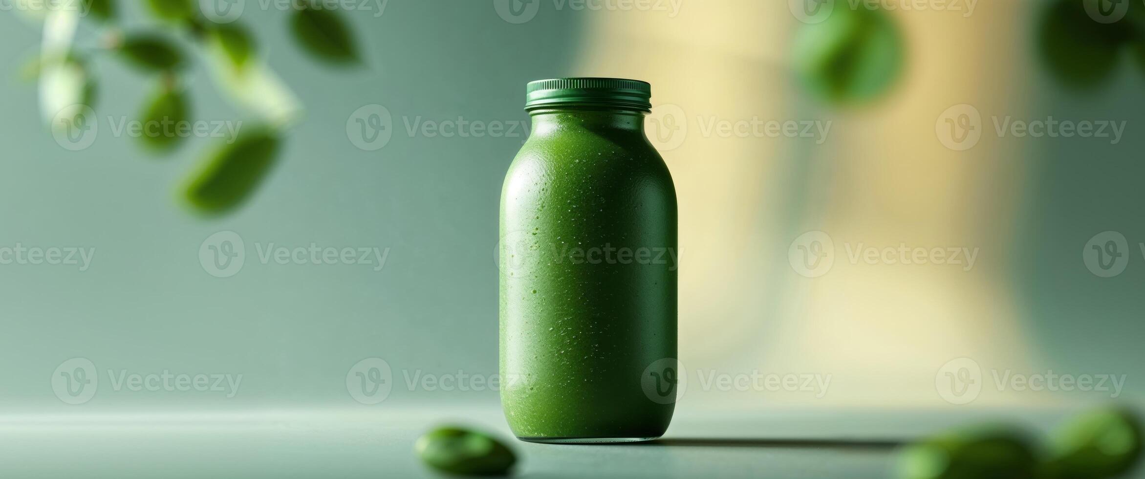 A green bottle of juice sitting on a table photo