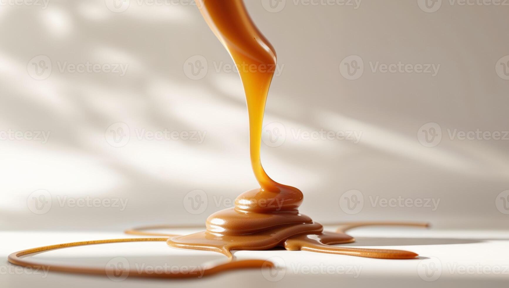 A caramel liquid being poured into a glass photo
