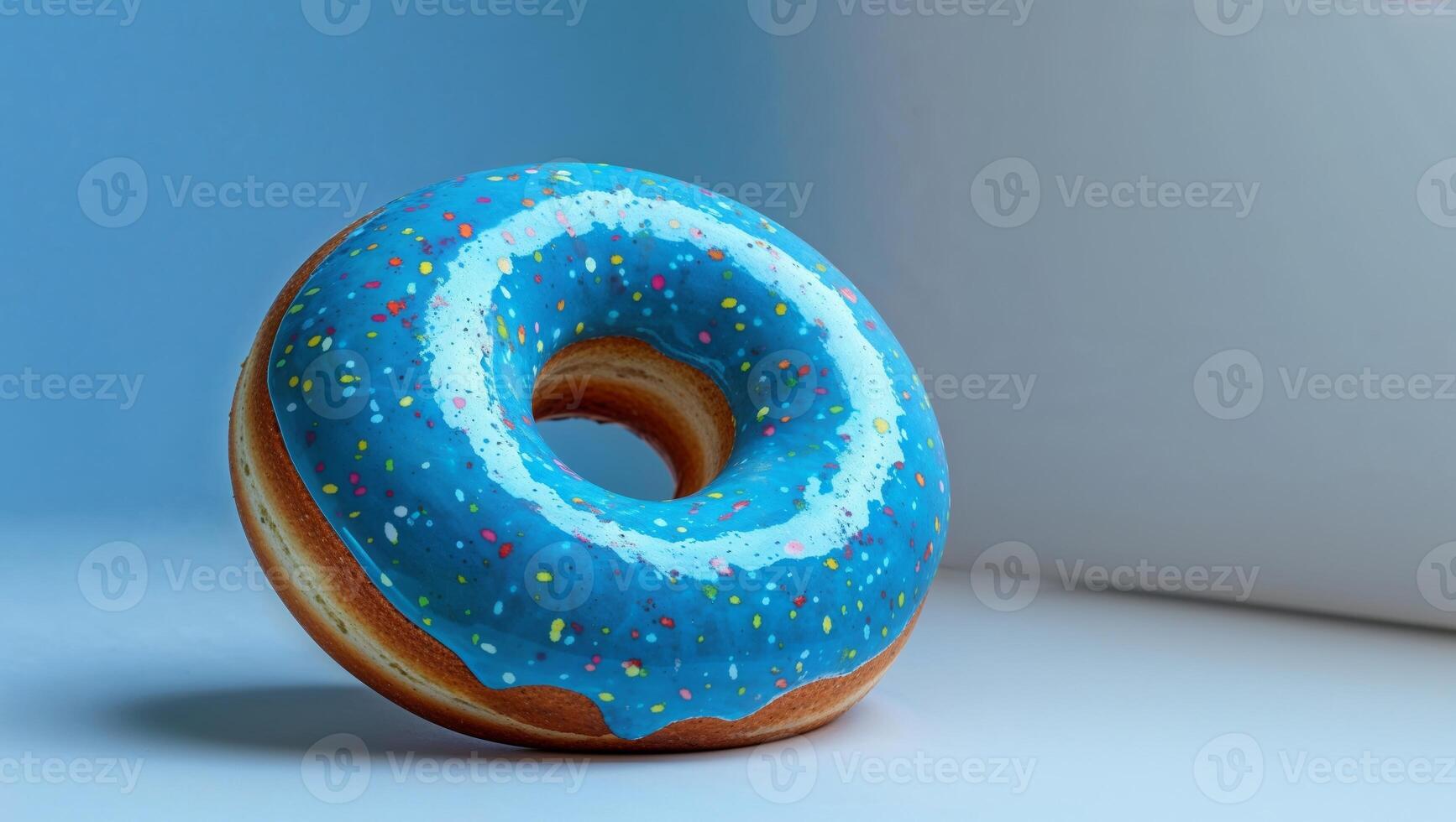 A blue donut with sprinkles on top of a table photo