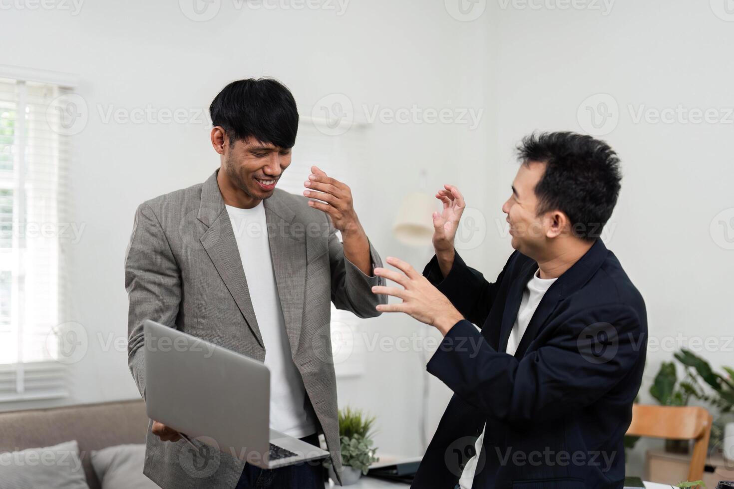 Business Strategy and Team Spirit. Two men celebrating a successful collaboration, reflecting teamwork and positive energy in a modern office. photo