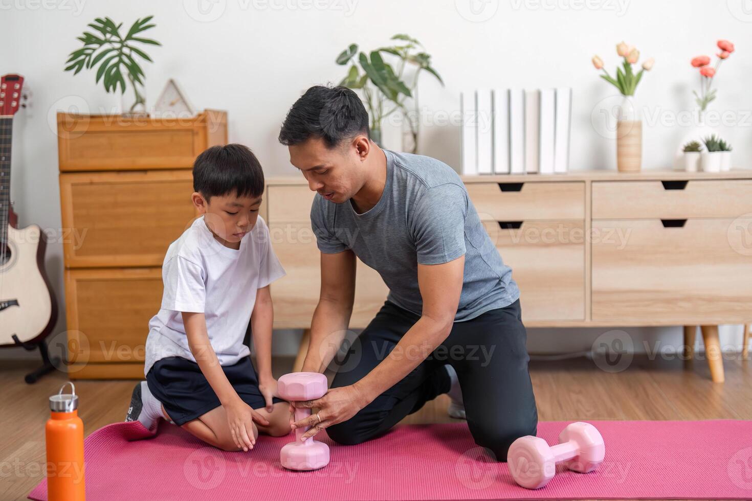 Family exercising together. Father and son using dumbbells at home photo