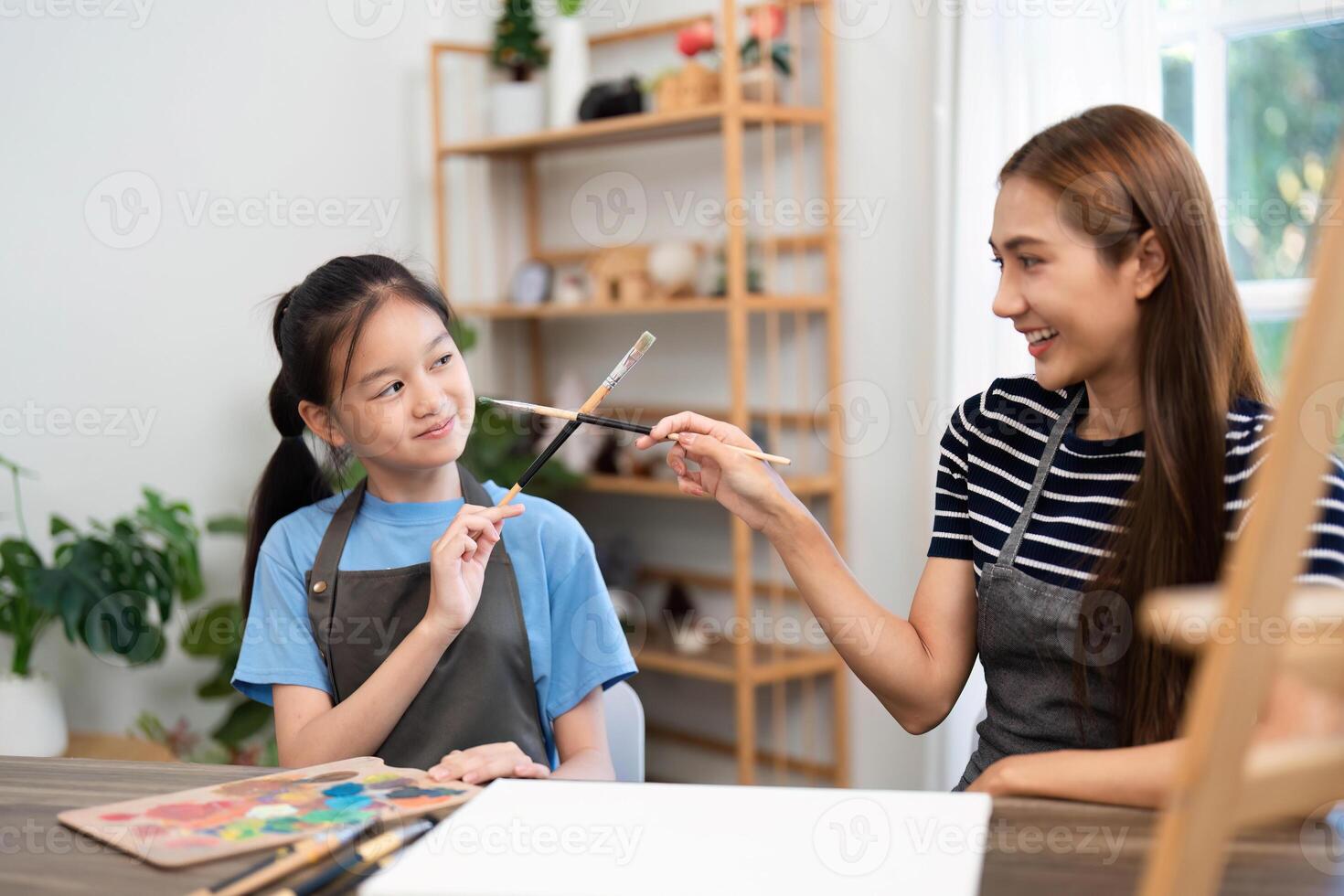 Learning together. Women and child engaging in fun painting activity photo