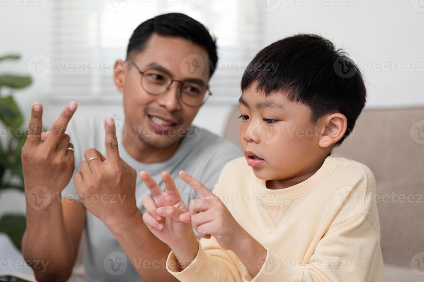 Homeschool activity with father showing math problems to son photo