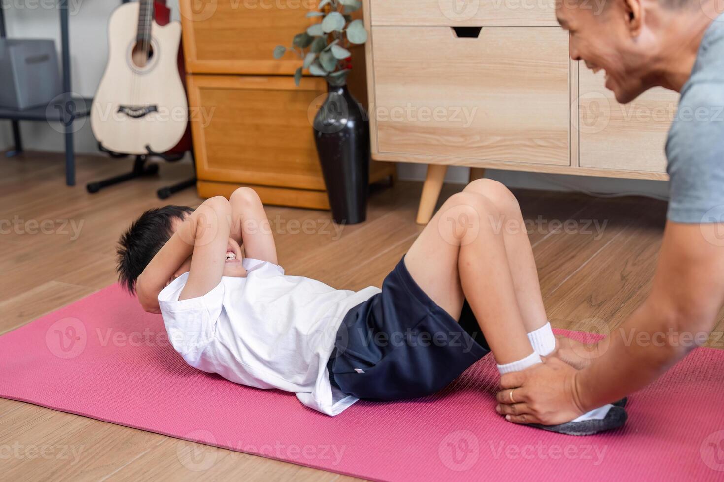 Family playful workout father and son doing crunches together at home photo