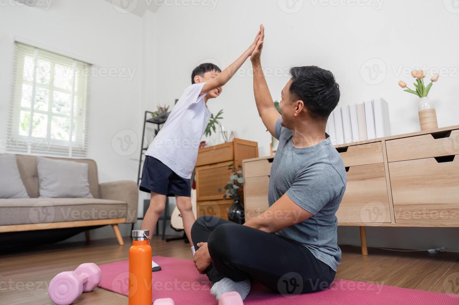 Family fitness fun with father and son high-fiving at home photo