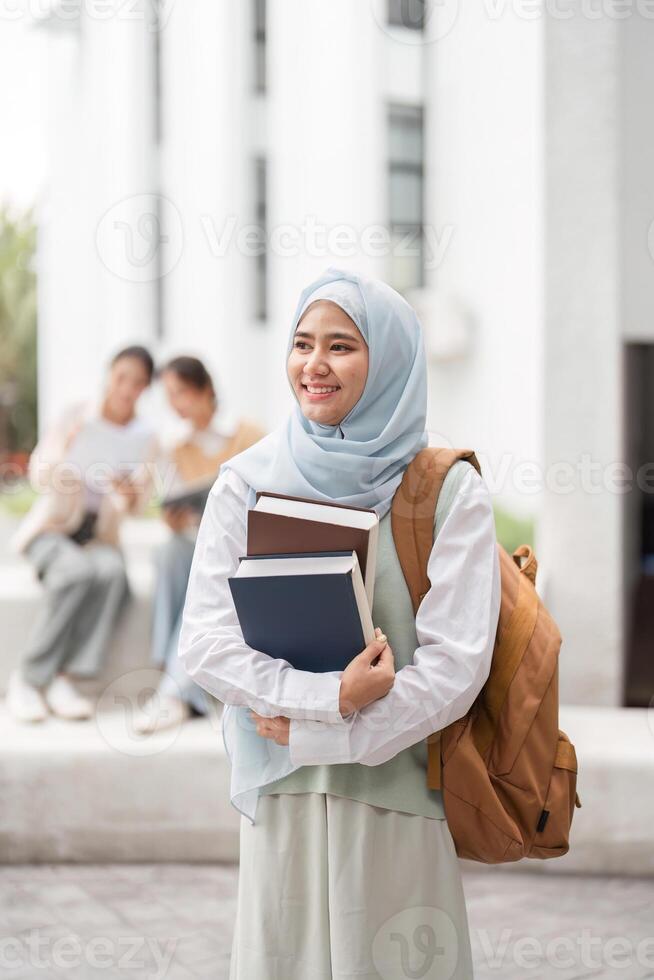 Diverse female student holding books and smiling on a university campus. photo