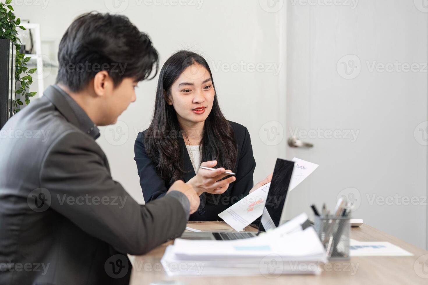 Business professionals discussing financial reports and strategies in a modern office setting. photo