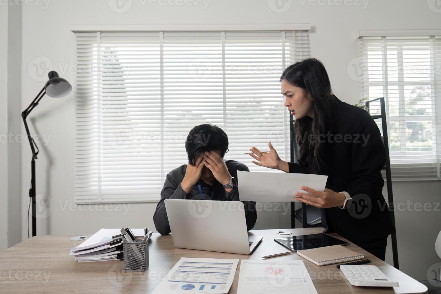 Business professional expressing frustration while discussing project issues with a colleague at the office. photo