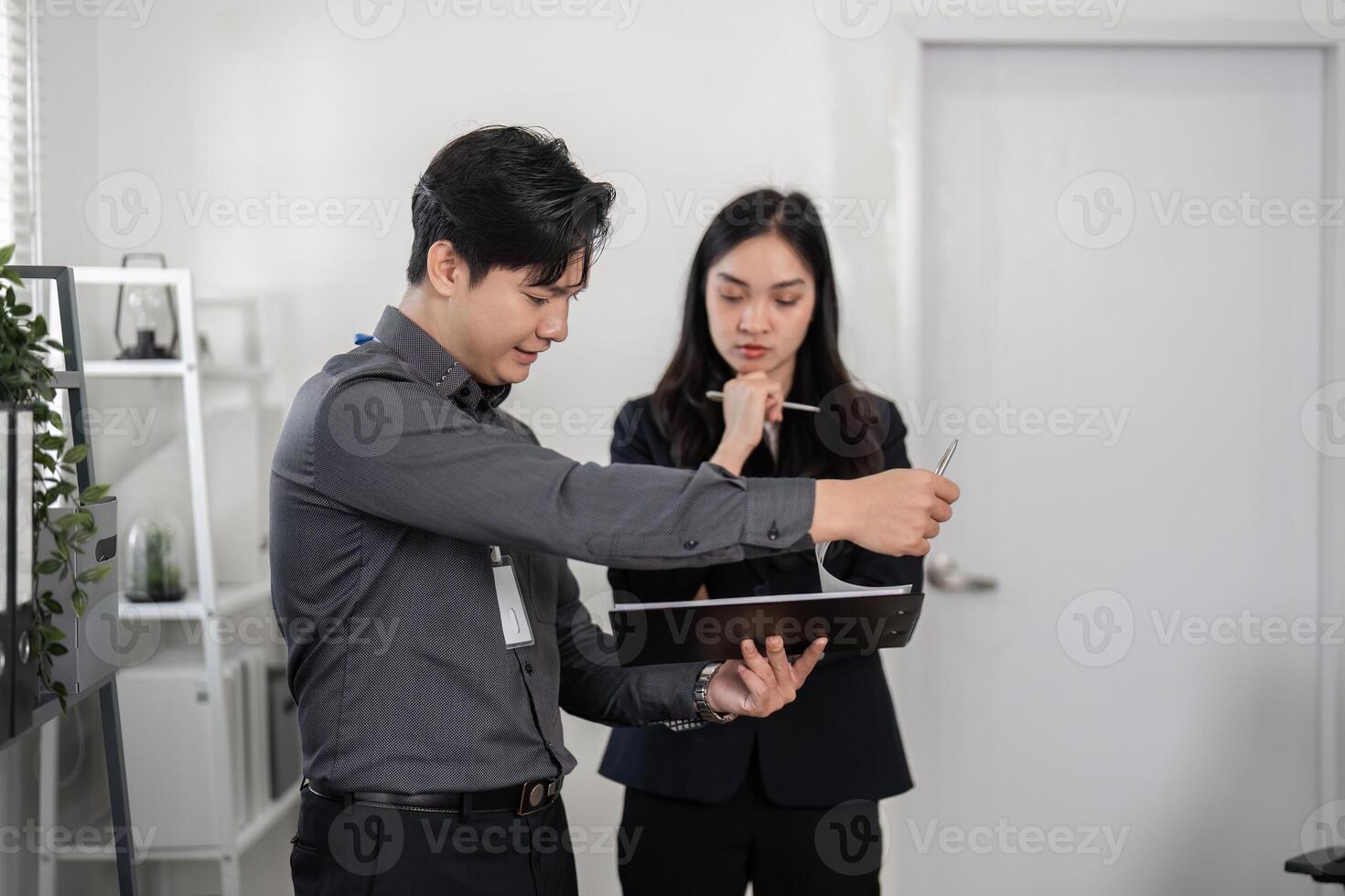 Business professionals analyzing data in a modern office, demonstrating focus and problem-solving skills. photo