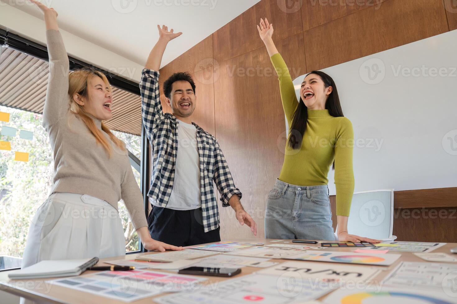 Excited diverse team celebrating successful UX design ideas, showcasing collaboration and innovation in a modern office. photo