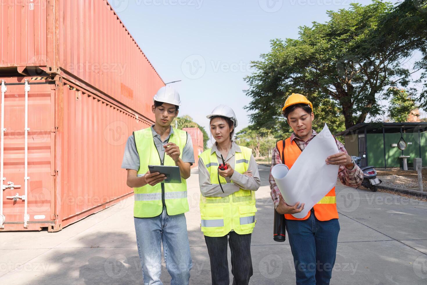 Construction professionals collaborating with blueprints and a tablet at a vibrant construction site photo
