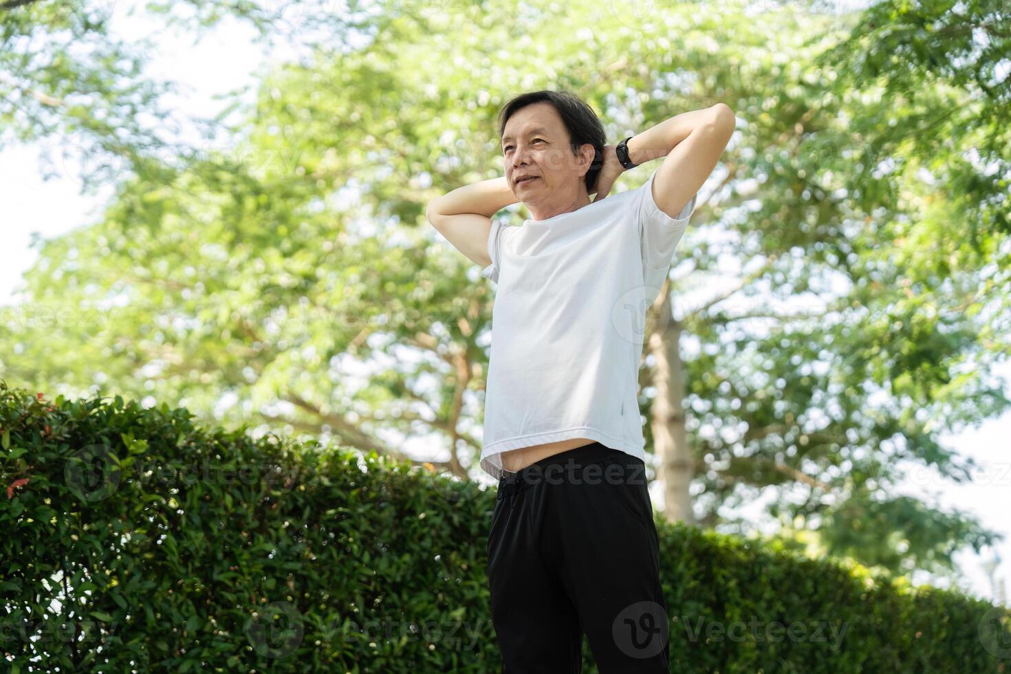 Wellness and Relaxation. Senior man stretching and enjoying nature. photo