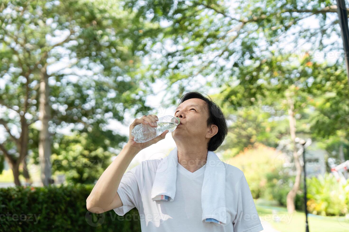 Hydration and Wellness. Man drinking water during a refreshing break in the park. photo