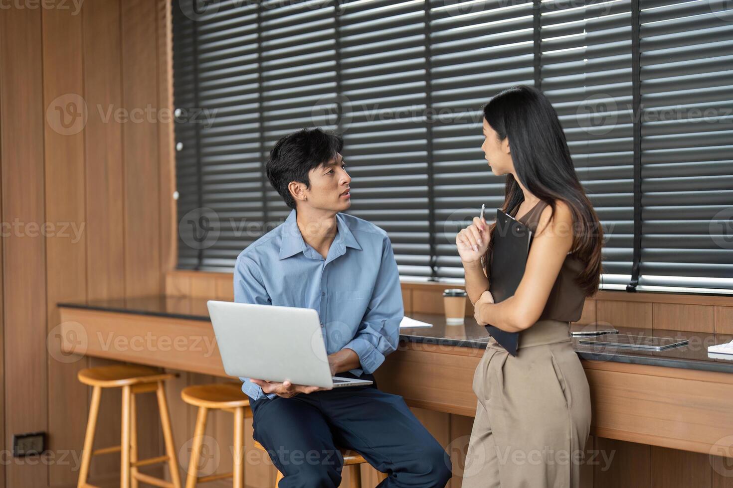 Business Interaction and Teamwork. Two young professionals engaged in a discussion in a modern office. photo