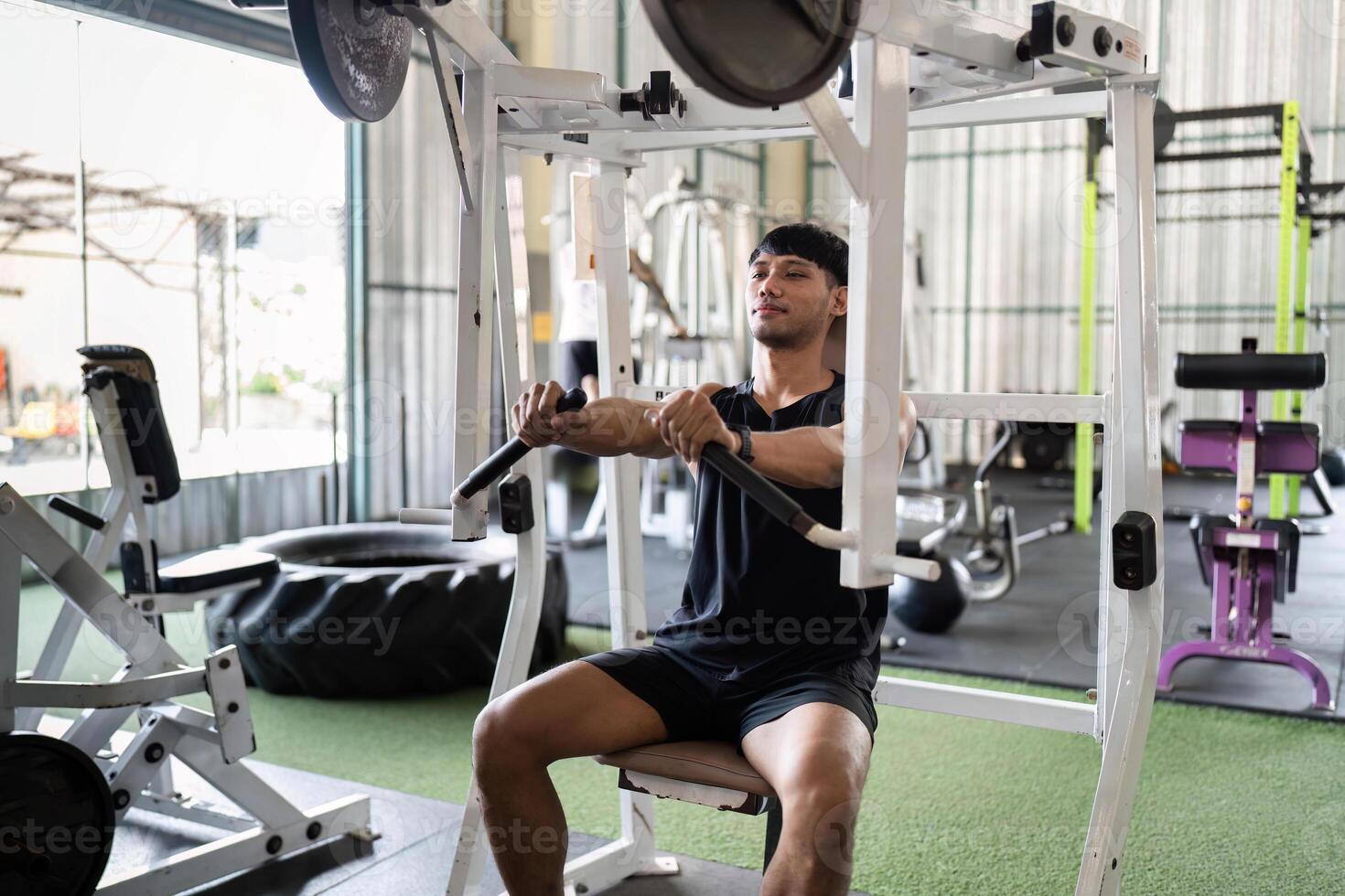 Fitness Training. Young Man Engaging in Strength Workout at Gym photo