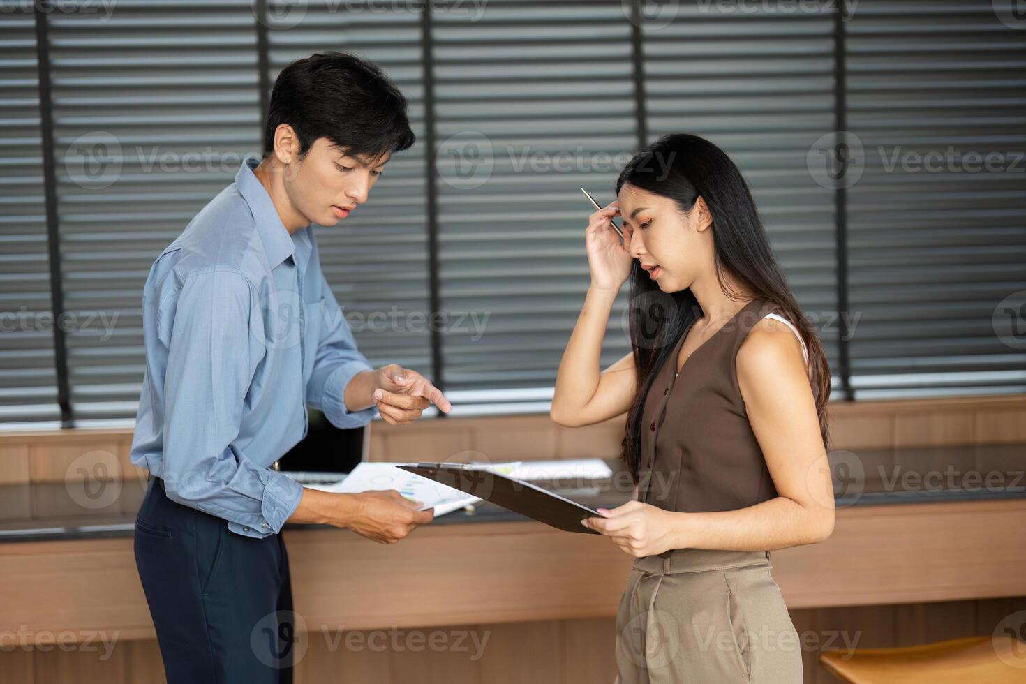 Business Collaboration. Two professionals discussing project details in a modern office. photo