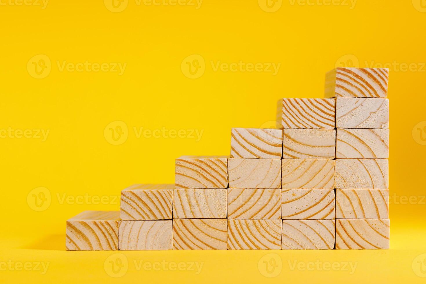 Wooden blocks forming stairway on yellow background. Ladder of success photo