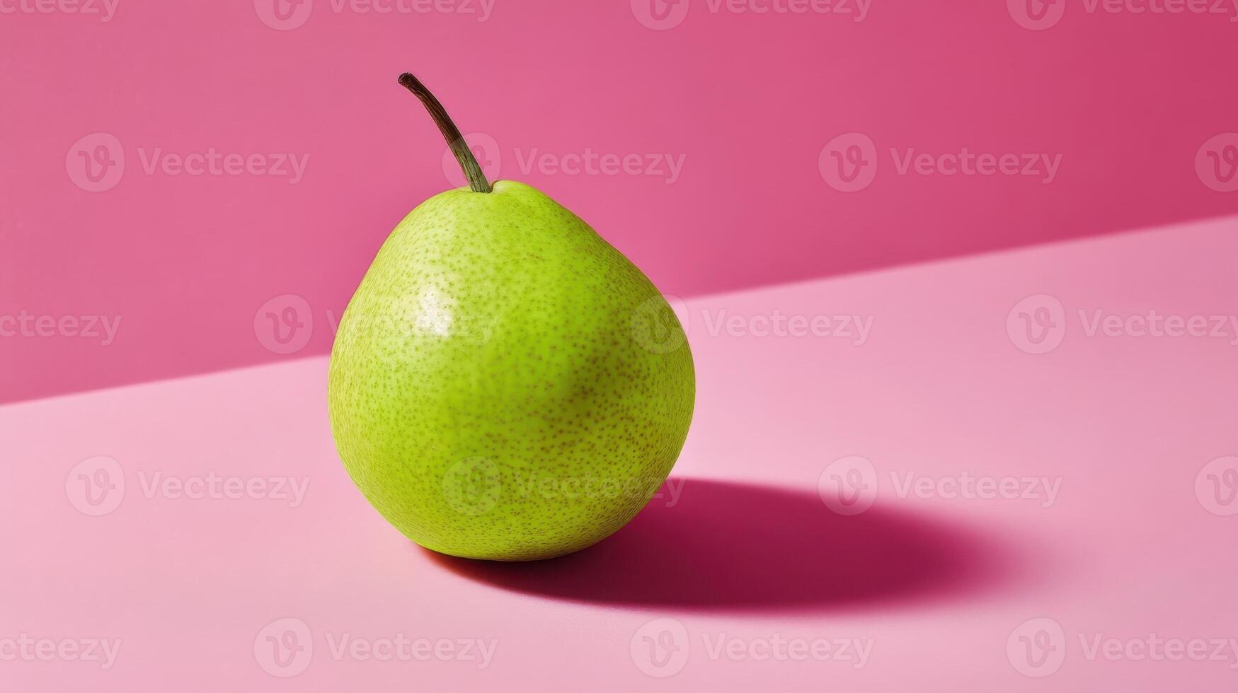 A single green pear on a pink background photo