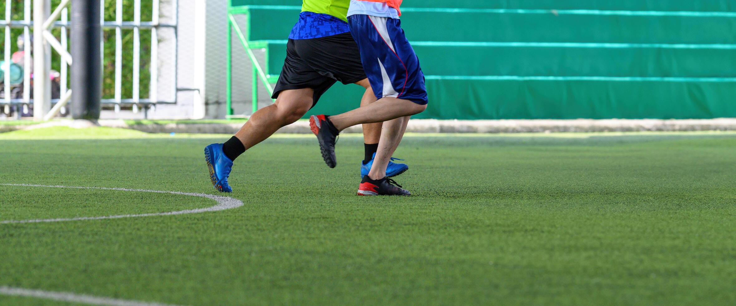 Soccer players in action during game on grass field focusing on their legs and ball, showing dynamic movement and athletic footwear in competitive setting photo