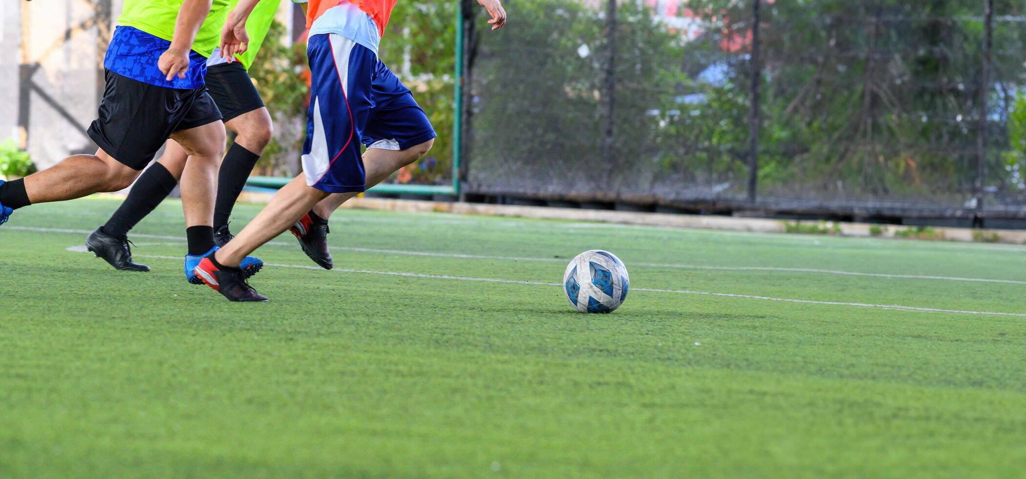 Soccer players in action on green grass field focusing on their legs and ball during game with motion and energy photo