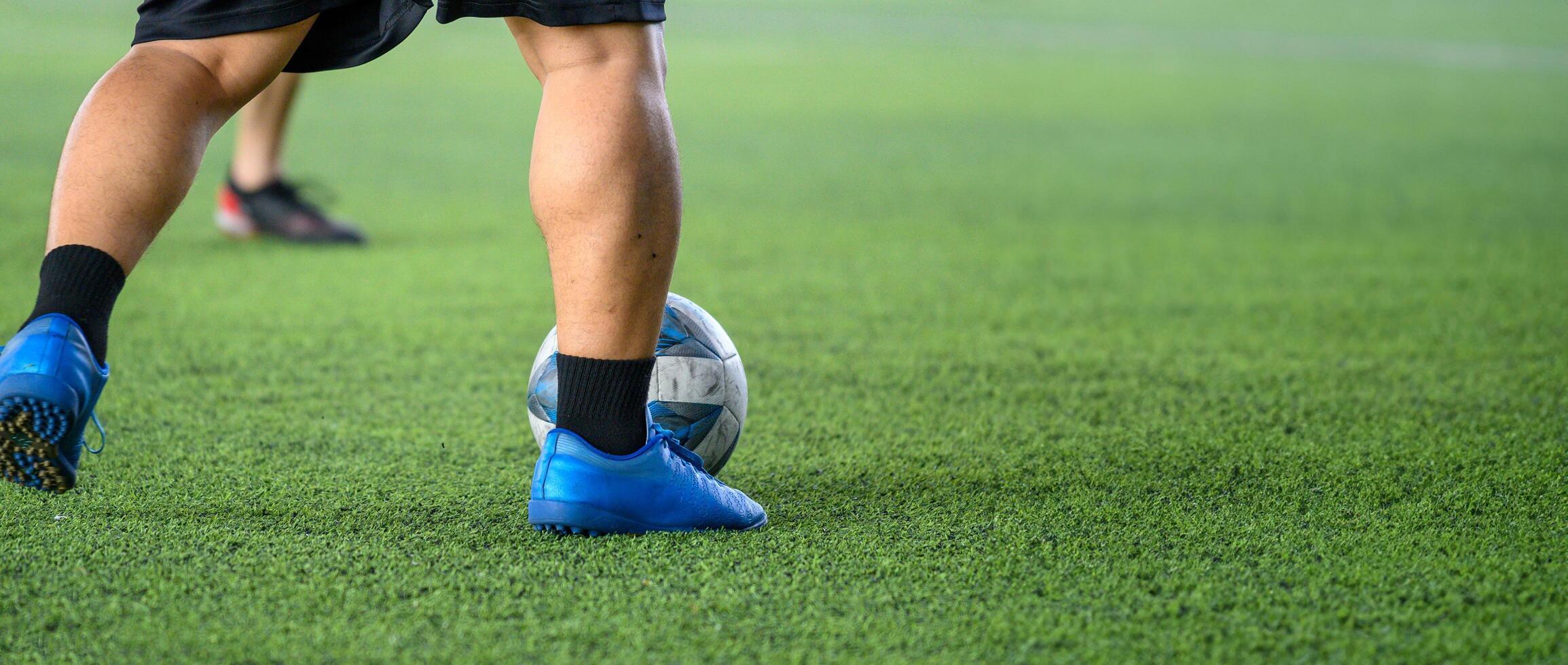 Soccer players in action on green grass field focusing on their legs and ball, showing dynamic movement and sports energy during game photo