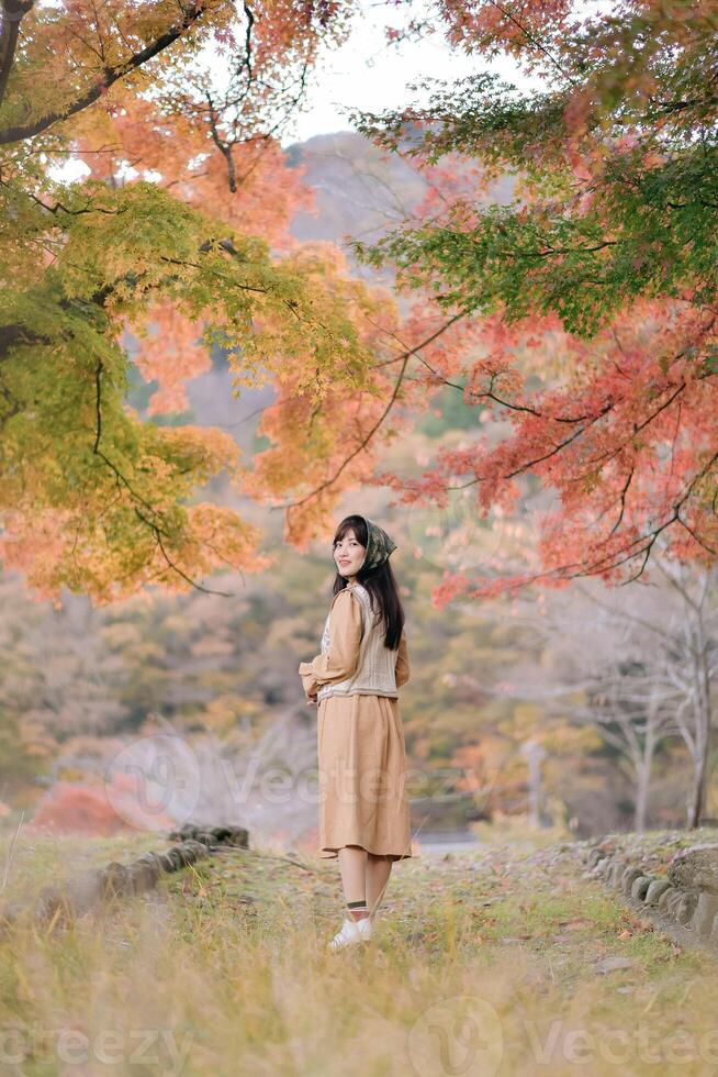 Southeast asian woman enjoys travel in autumn nature surrounded by colorful leaves and peaceful scenery creating warm and calm concept of outdoor exploration photo