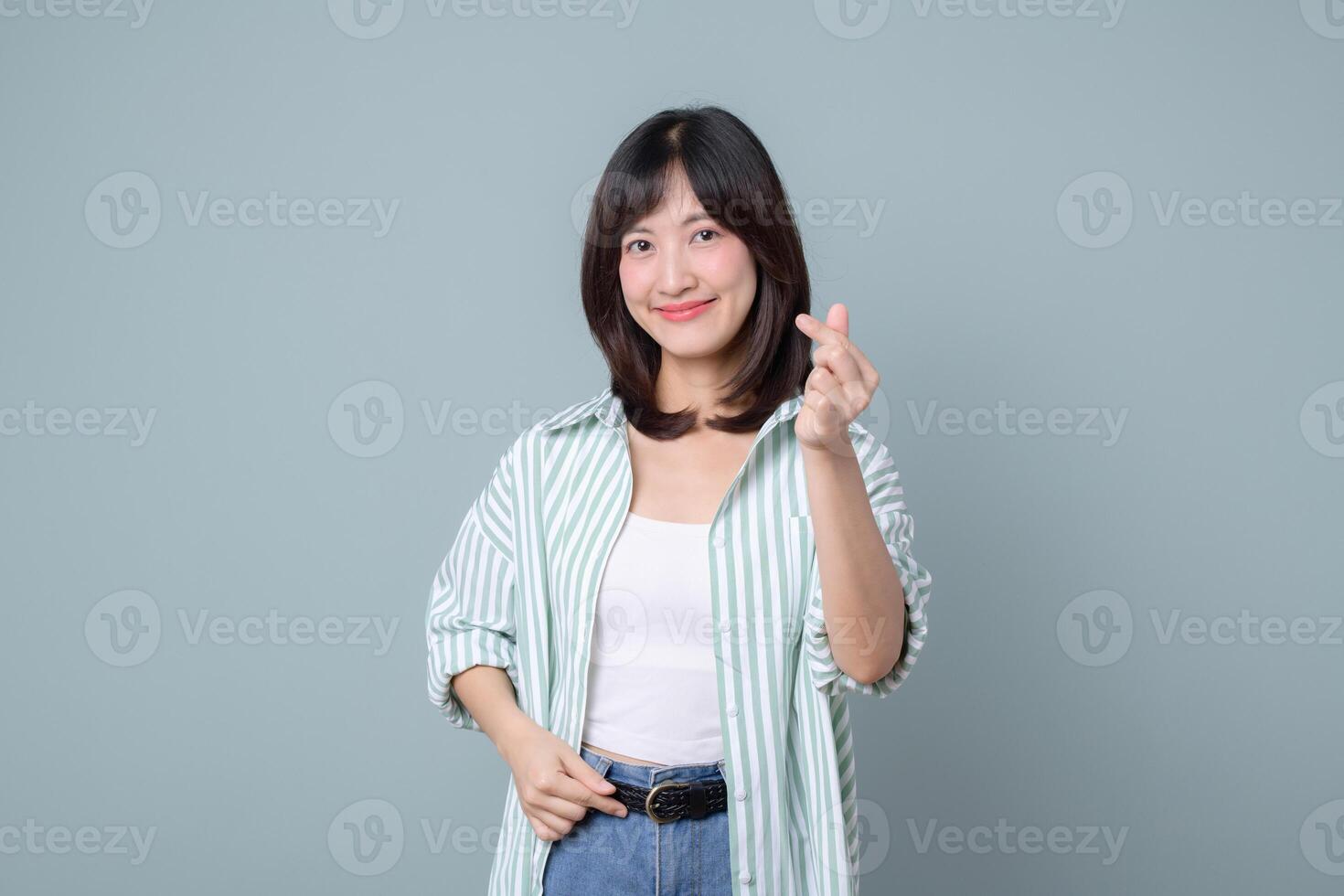 Southeast asian woman smiles creatively showing small heart gesture symbolizing love for her retail business and online startup store in creative industry of shopping photo