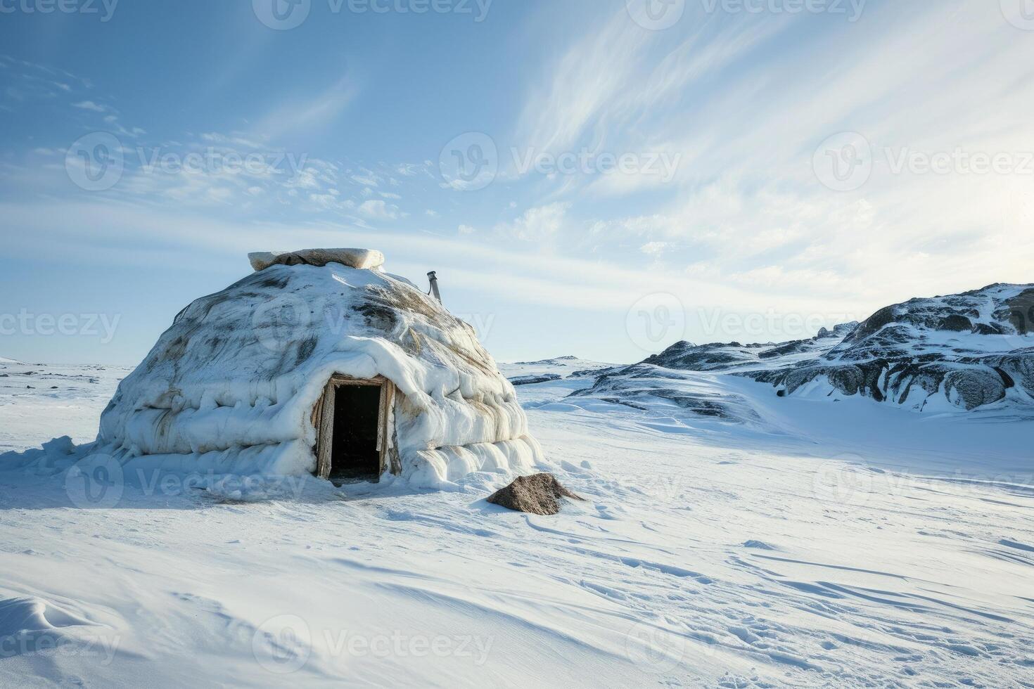 A glowing igloo in a tranquil, snow-covered valley, with the northern lights above. photo
