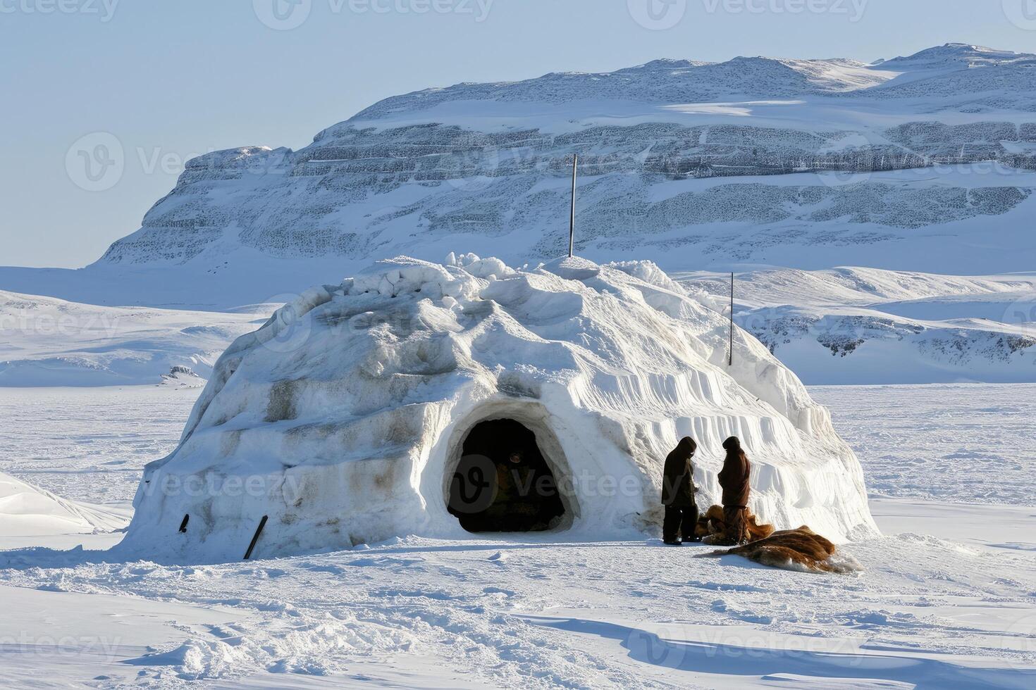 A cozy igloo perched on a frozen hillside, with sparkling snowflakes gently falling. photo