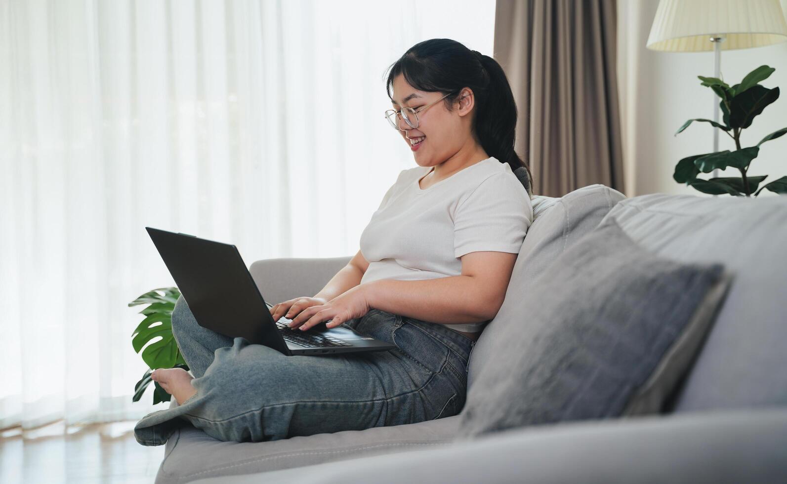 Asian woman working on laptop computer, sending email, studying online, social networking photo