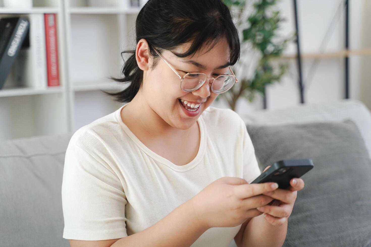 Young Asian woman is using her smartphone, chatting, texting, social networking photo