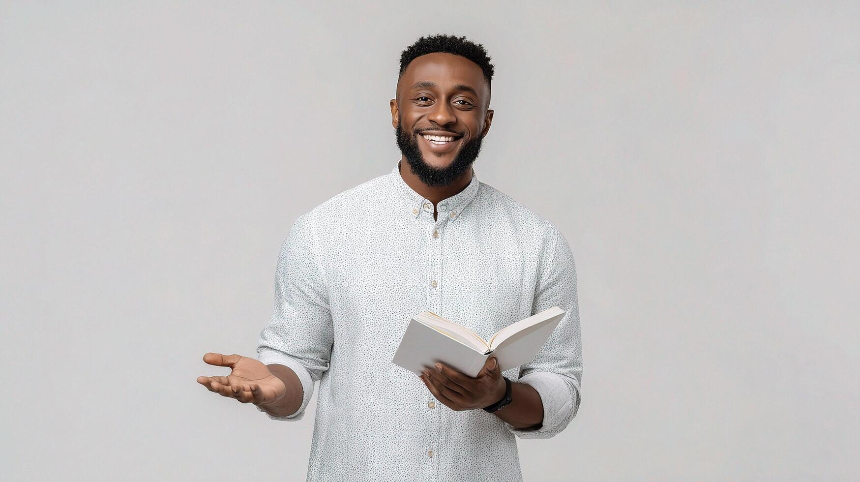 A smiling black man holding a book and smiling photo